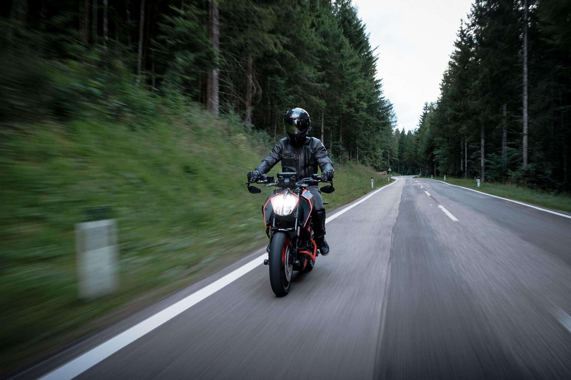 Motorcyclist riding a KTM Duke 390 through a forest